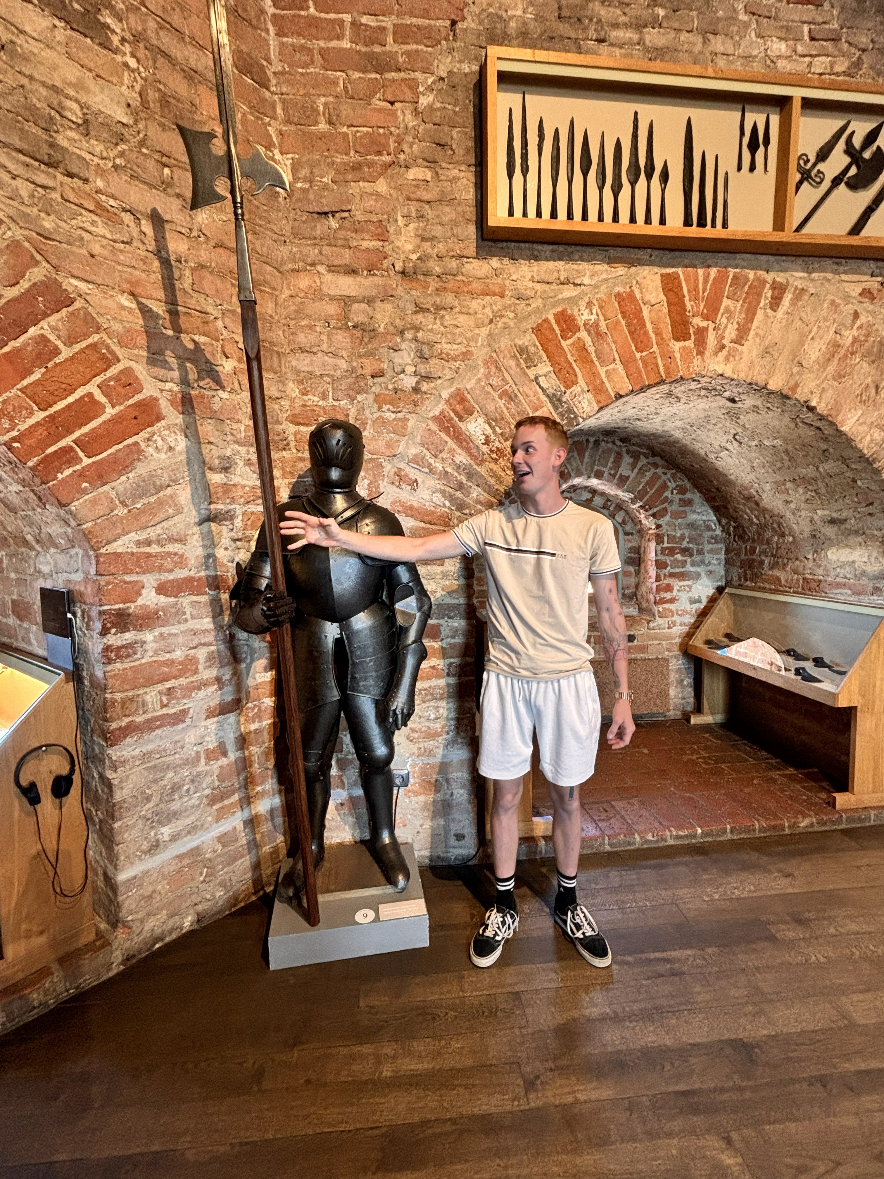 Aiden casually posing with armor, as one does when your girlfriend keeps dragging you through castles.
